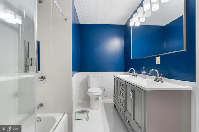 a bathroom with a double vanity sink toilet and shower