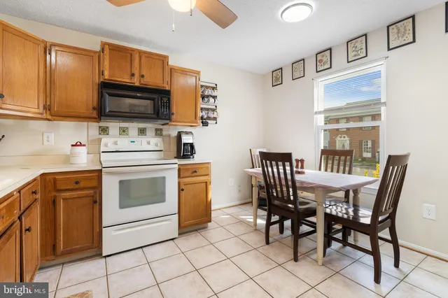 a kitchen with stainless steel appliances a stove a sink cabinets and a dining table