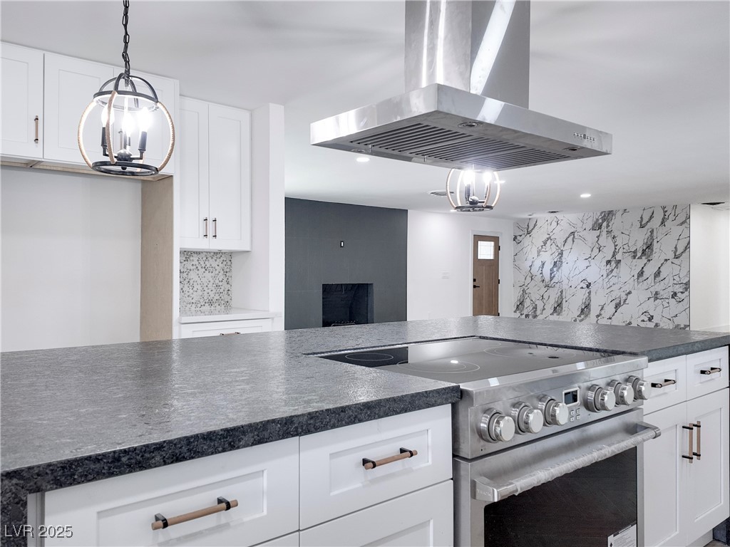 4501 South Woodcrest Road Las Vegas, NV 89121 - Photo 16 of 78 Kitchen with island range hood, a chandelier, high end stainless steel range, hanging light fixtures, and white cabinets