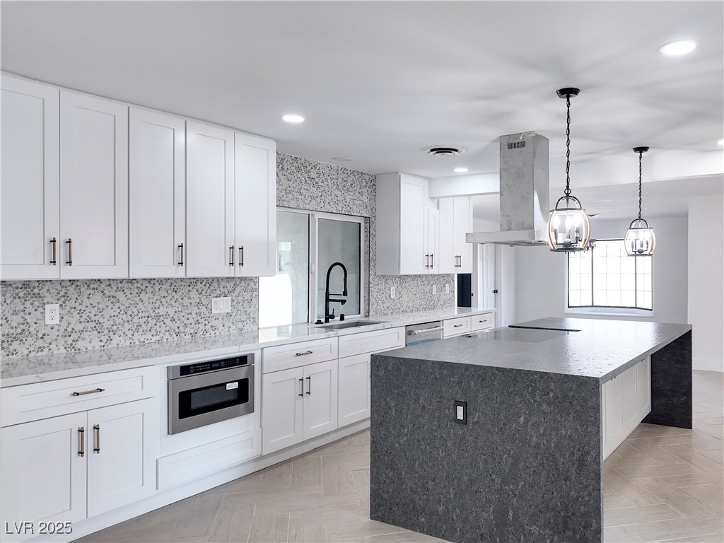 4501 South Woodcrest Road Las Vegas, NV 89121 - Photo 18 of 78 Kitchen with white cabinets, light stone countertops, tasteful backsplash, a center island, and recessed lighting