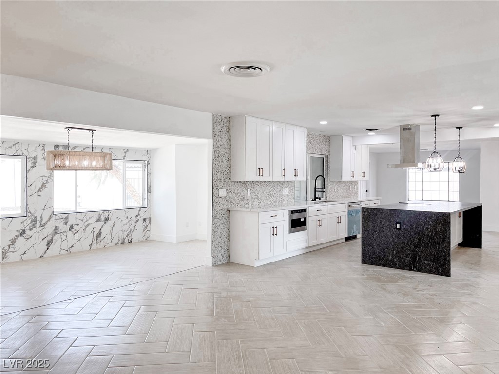 4501 South Woodcrest Road Las Vegas, NV 89121 - Photo 19 of 78 Kitchen with decorative light fixtures, white cabinets, a center island, a chandelier, and light stone countertops
