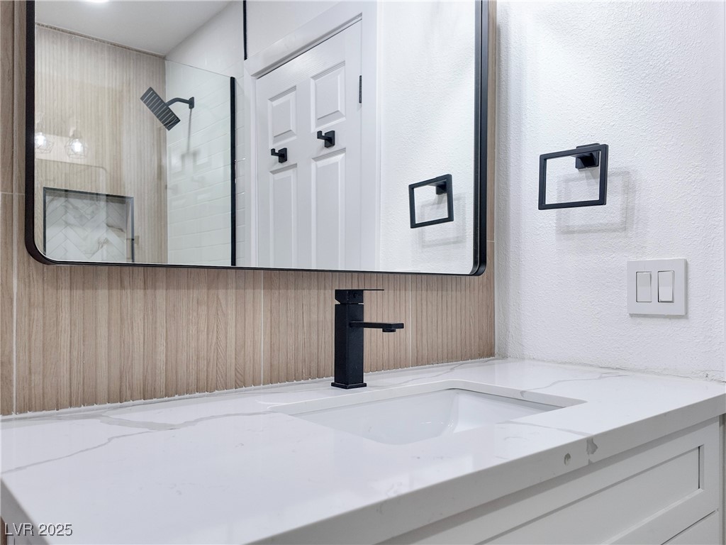 4501 South Woodcrest Road Las Vegas, NV 89121 - Photo 46 of 78 Full bath with vanity, a textured wall, and tiled shower