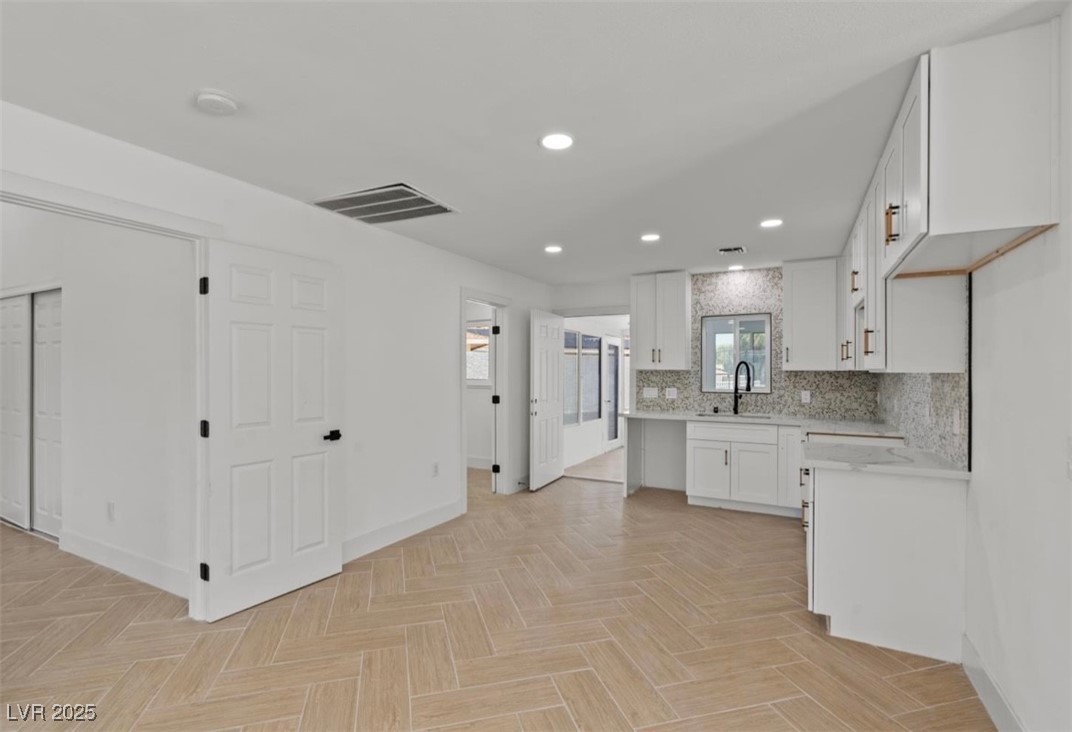 4501 South Woodcrest Road Las Vegas, NV 89121 - Photo 67 of 78 ATTACHED APARTMENT Kitchen featuring white cabinets, tasteful backsplash, recessed lighting, and light stone countertops