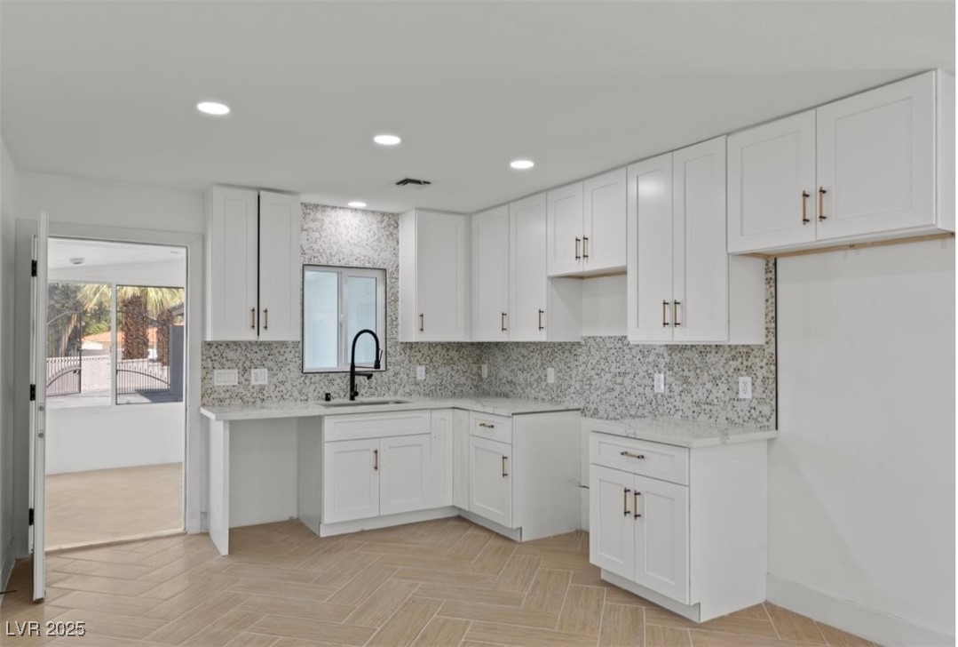 4501 South Woodcrest Road Las Vegas, NV 89121 - Photo 68 of 78 ATTACHED APPARTMET Kitchen with white cabinetry, backsplash, recessed lighting, and light stone countertops