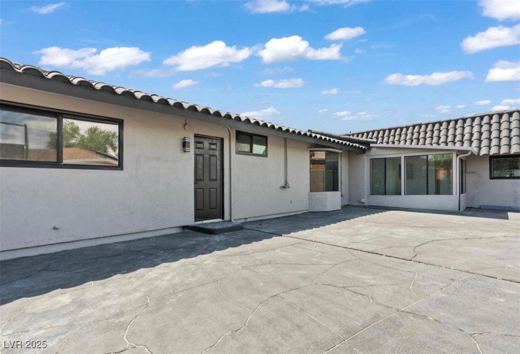 4501 South Woodcrest Road Las Vegas, NV 89121 - Photo 75 of 78 Rear view of property with a tiled roof, a patio, and stucco siding