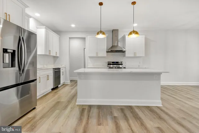 a view of a kitchen with stainless steel appliances granite countertop a sink a stove a refrigerator and island