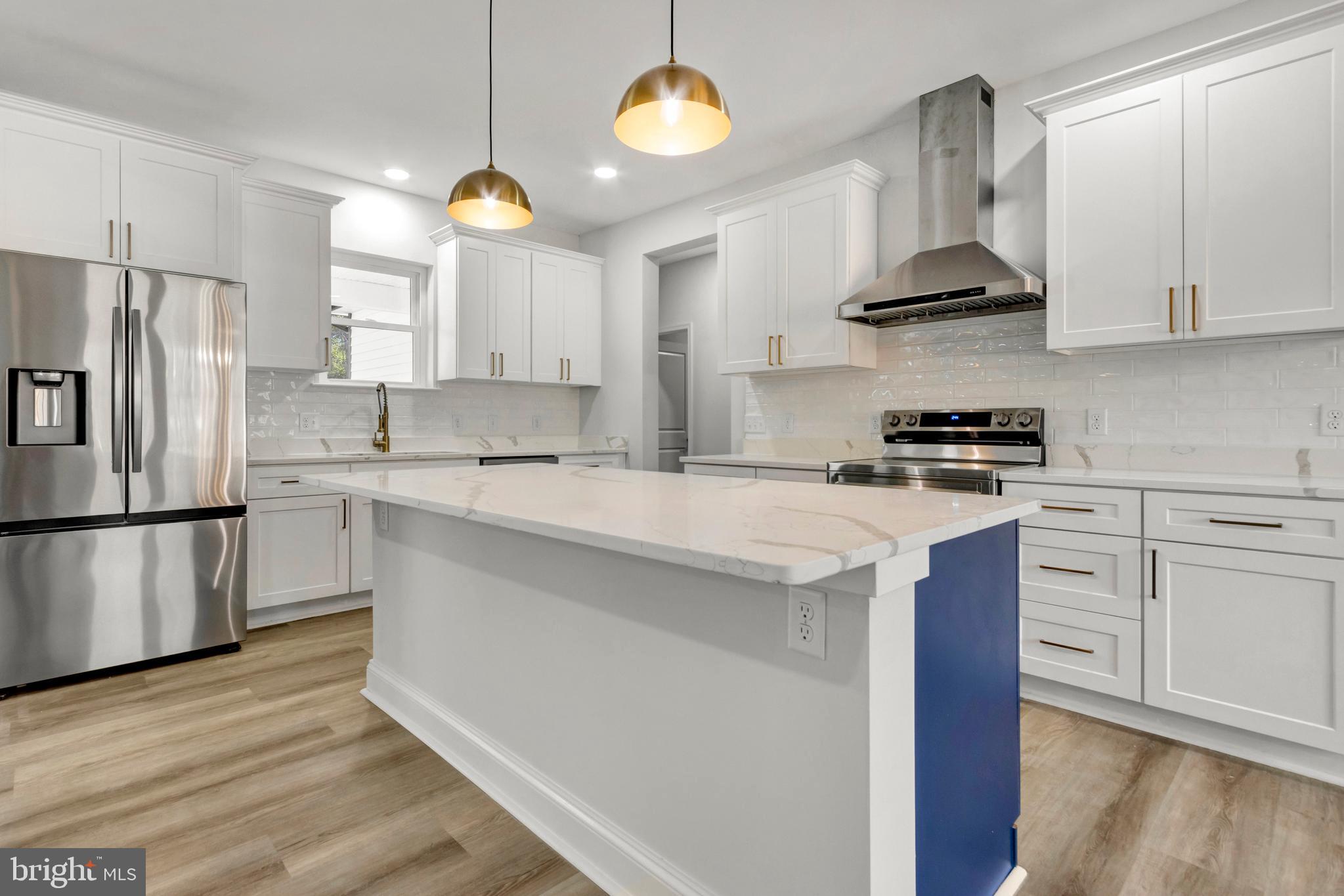 22527 Lawson Road Georgetown, DE 19947 - Photo 15 of 53 a kitchen with stainless steel appliances granite countertop a sink a stove a refrigerator and island with wooden floor