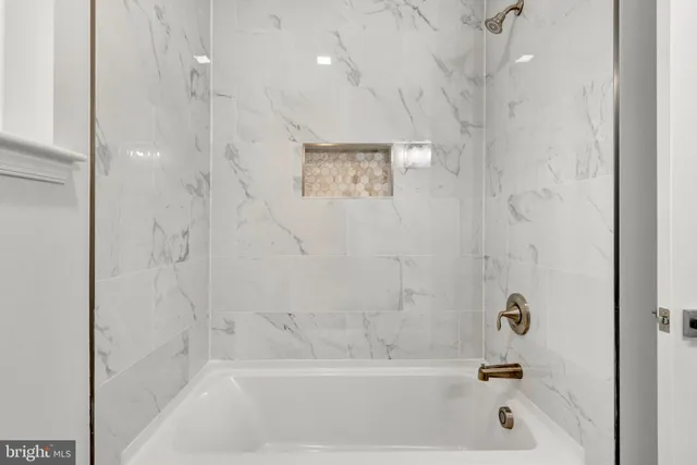 a white bath tub sitting next to a white door