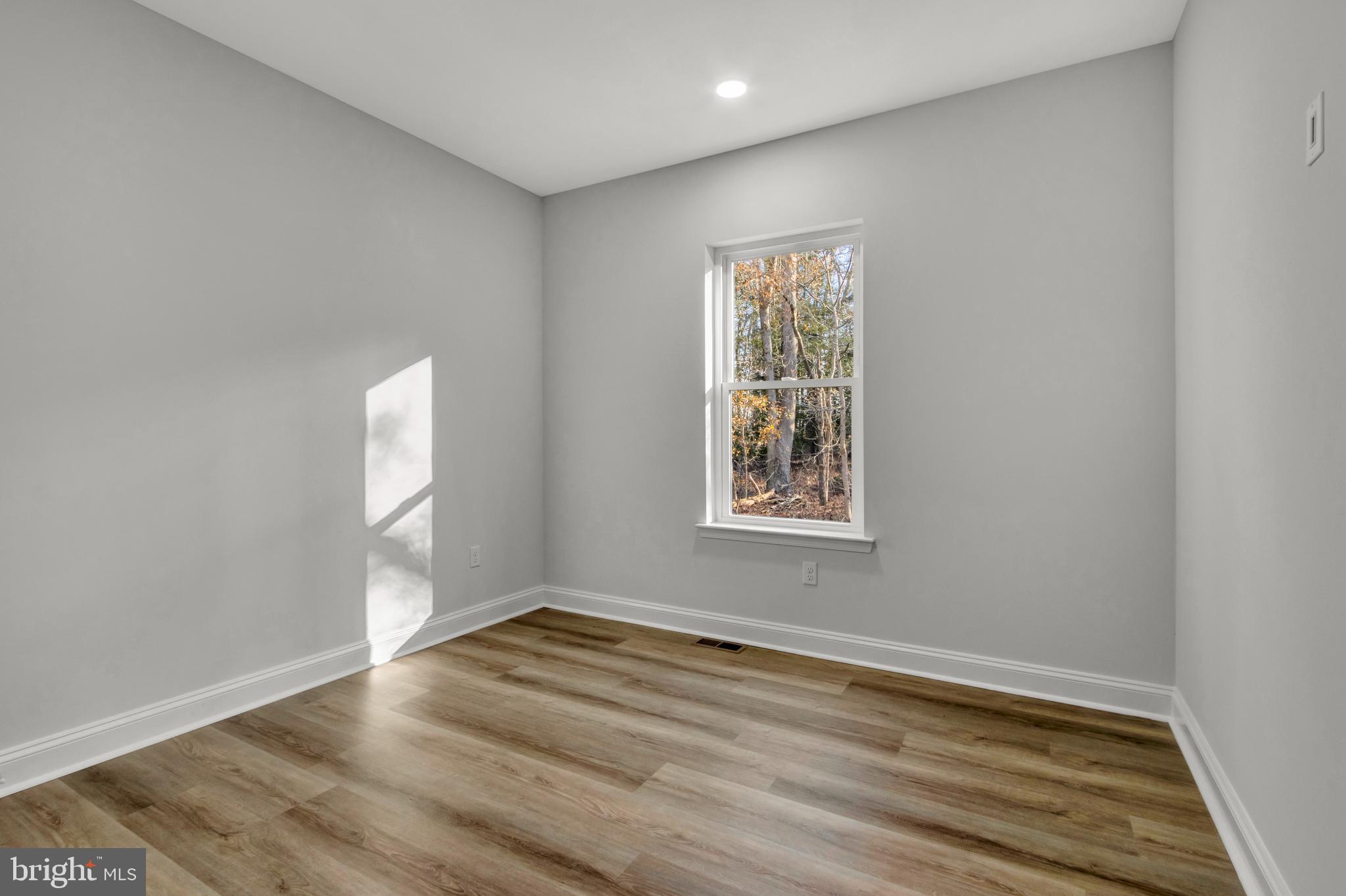 22527 Lawson Road Georgetown, DE 19947 - Photo 42 of 53 an empty room with wooden floor and windows