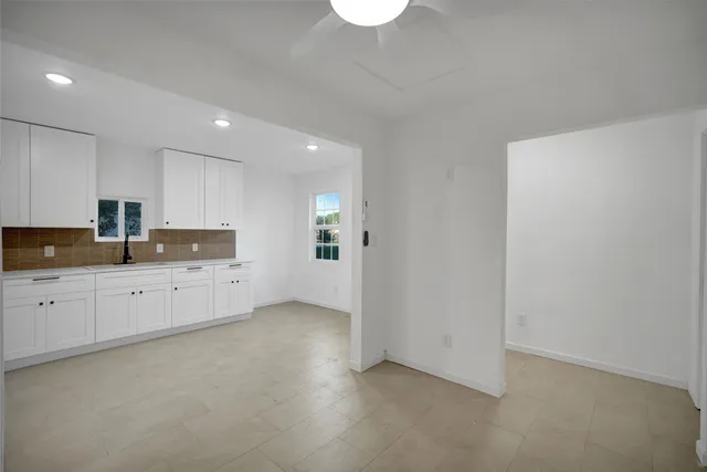 a kitchen with granite countertop white cabinets and stainless steel appliances
