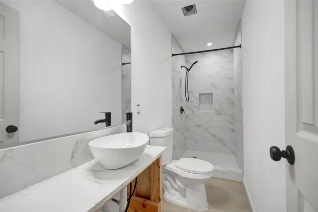 a bathroom with a toilet a sink and shower