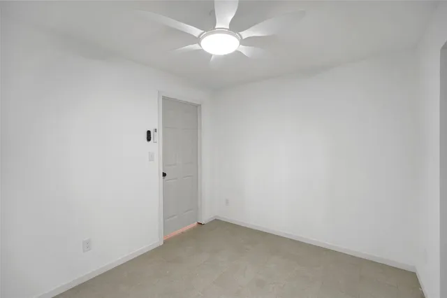an empty room with a ceiling fan and a fan