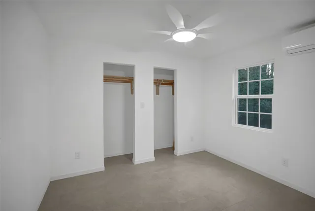 an empty room with windows and closet