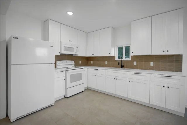 a kitchen with cabinets stainless steel appliances and sink
