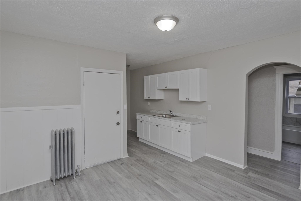 107 Orange Street Springfield, MA 01108 - Photo 11 of 38 a room with white cabinets and wooden floor
