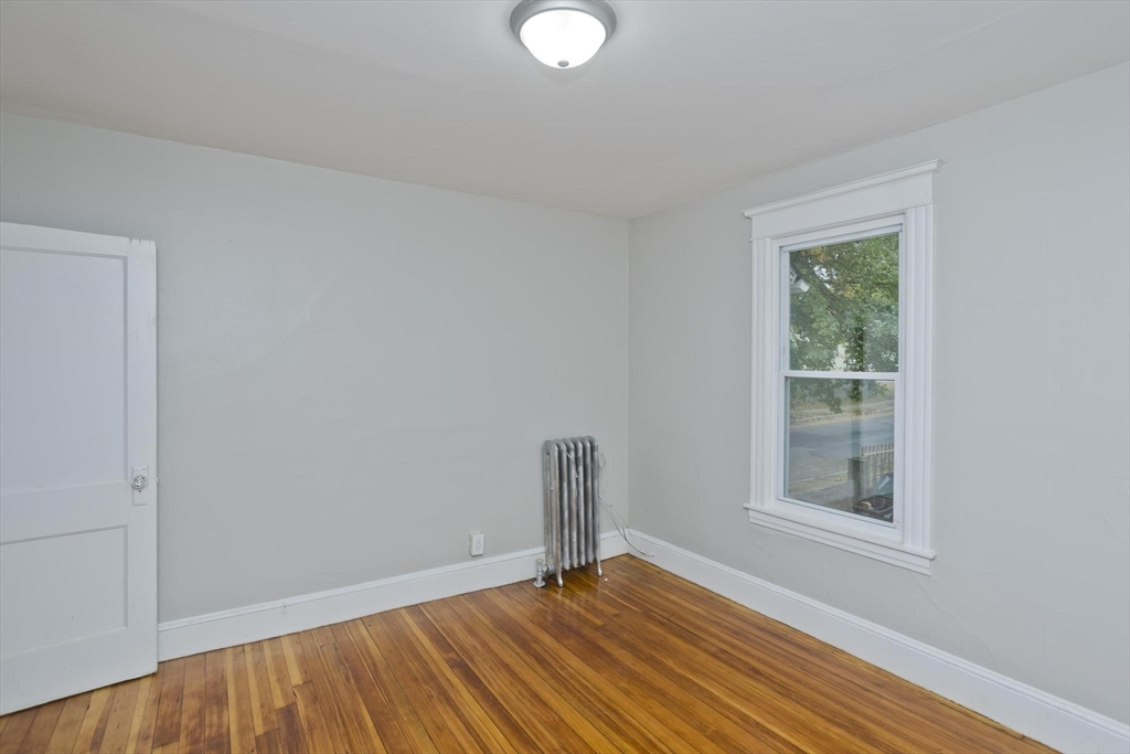 107 Orange Street Springfield, MA 01108 - Photo 16 of 38 a view of an empty room with wooden floor and a window