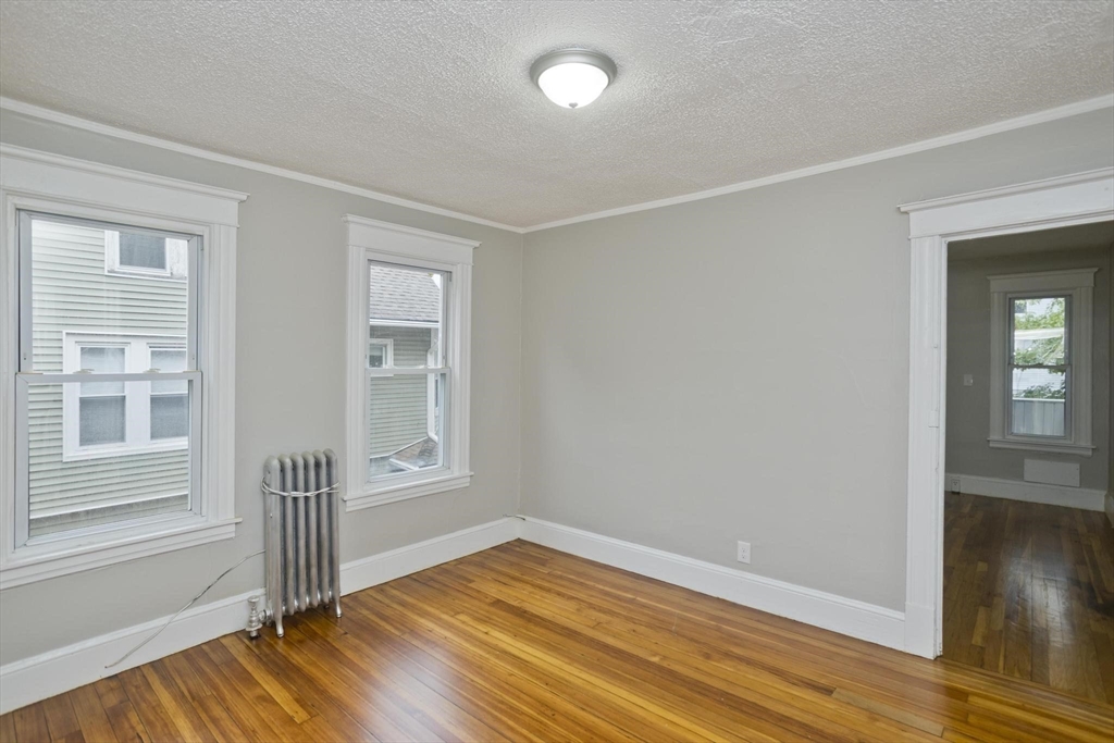 107 Orange Street Springfield, MA 01108 - Photo 19 of 38 a view of empty room with wooden floor and fan