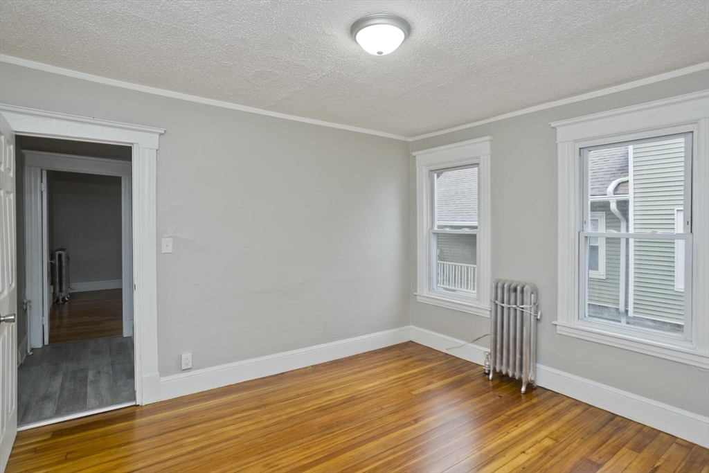 107 Orange Street Springfield, MA 01108 - Photo 21 of 38 a view of empty room with wooden floor and fan