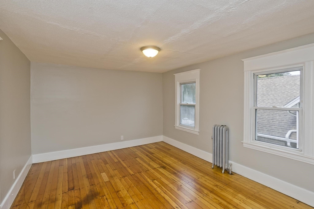107 Orange Street Springfield, MA 01108 - Photo 25 of 38 a view of empty room with wooden floor and fan