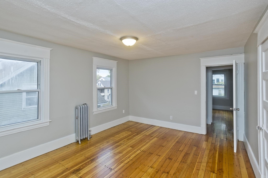 107 Orange Street Springfield, MA 01108 - Photo 27 of 38 a view of empty room with wooden floor and fan