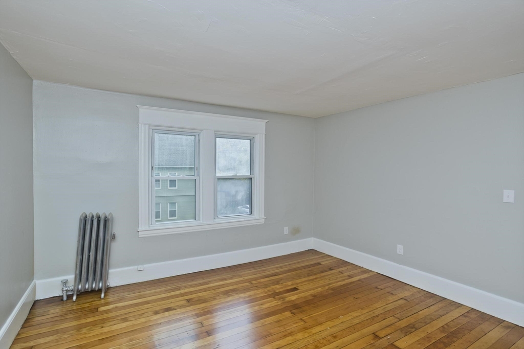 107 Orange Street Springfield, MA 01108 - Photo 28 of 38 an empty room with wooden floor and window