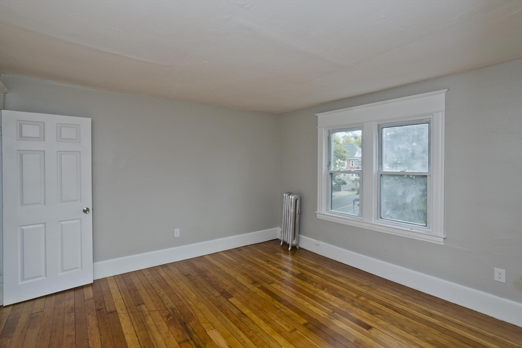 107 Orange Street Springfield, MA 01108 - Photo 30 of 38 an empty room with wooden floor and windows