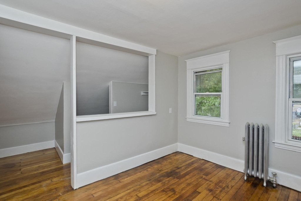 107 Orange Street Springfield, MA 01108 - Photo 31 of 38 a view of an empty room with wooden floor and a window