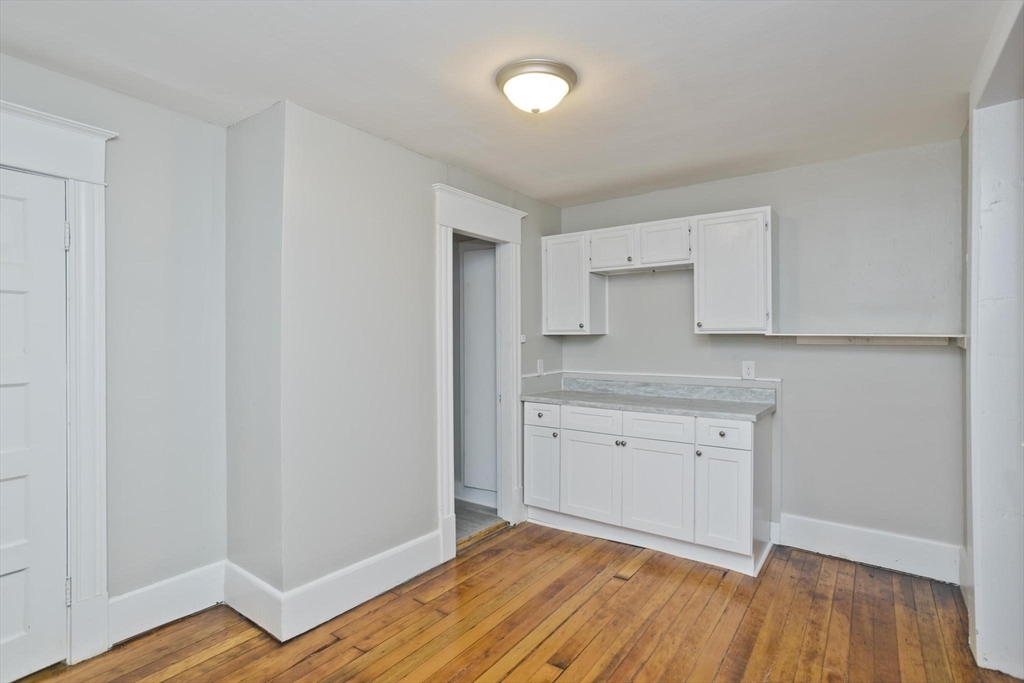 107 Orange Street Springfield, MA 01108 - Photo 33 of 38 a kitchen with granite countertop white cabinets and wooden floor