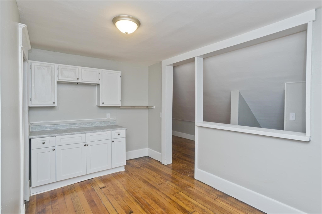 107 Orange Street Springfield, MA 01108 - Photo 34 of 38 a view of cabinets a wooden floor and a window in a room