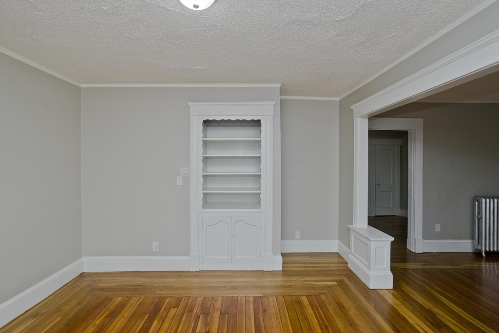 107 Orange Street Springfield, MA 01108 - Photo 10 of 38 a view of an empty room with wooden floor and closet