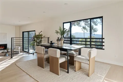 a dining room with furniture a large window and a fireplace