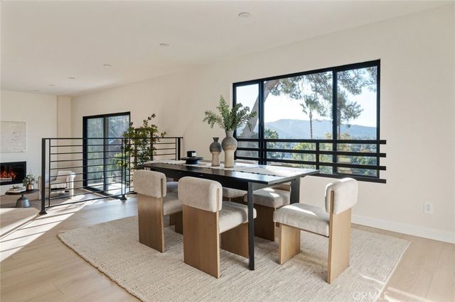 a dining room with furniture a large window and a fireplace