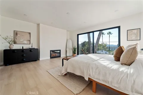 a bedroom with a bed and a large window