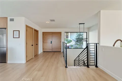 a view of a hallway with wooden floor and entryway