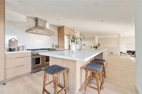 a kitchen with stainless steel appliances kitchen island granite countertop a table chairs in it and wooden floors