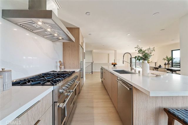 a kitchen with stainless steel appliances a sink dishwasher stove and oven