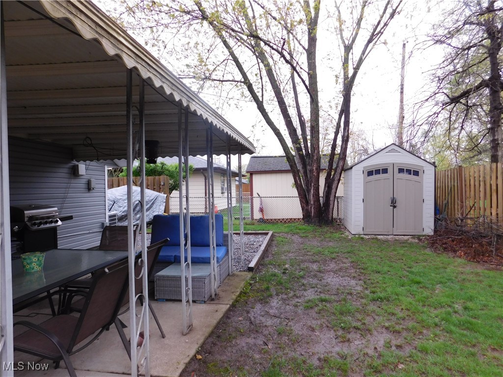 9720 West Ridgewood Drive Parma Heights, OH 44130 - Photo 43 of 46 View of yard with a storage unit, an outdoor structure, a fenced backyard, and and carport patio area