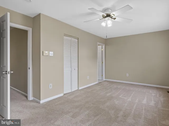 a view of an empty room with a ceiling fan