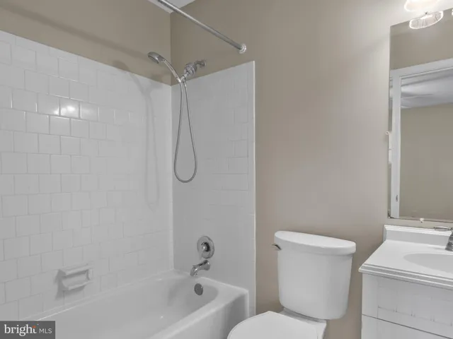 a white toilet sitting next to a bath tub