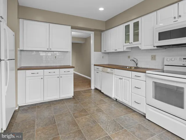 a kitchen with white cabinets stainless steel appliances and sink