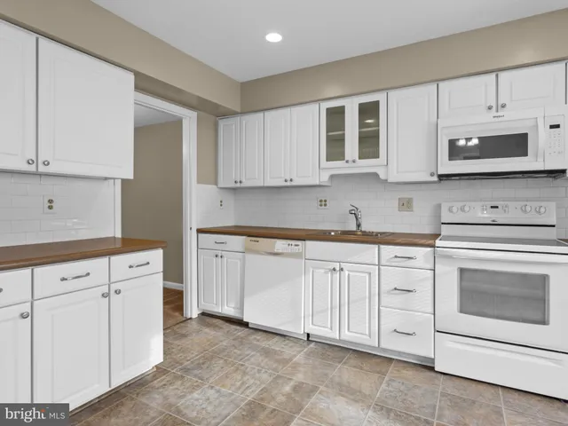 a kitchen with cabinets stainless steel appliances and sink
