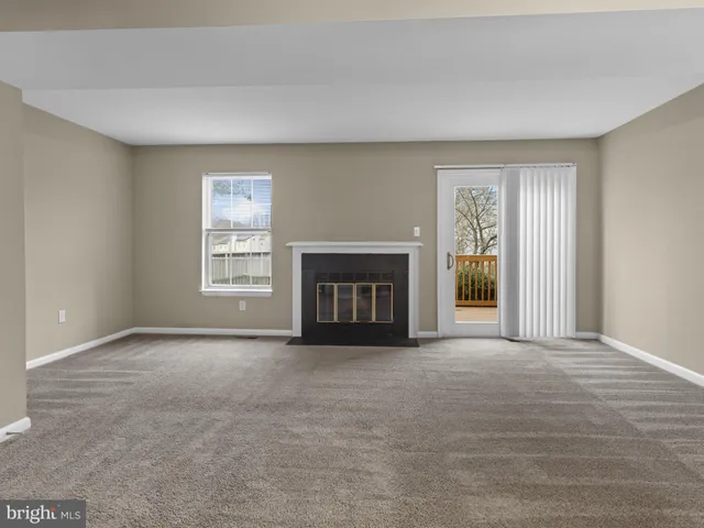 a view of an empty room with a window and fireplace