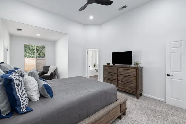 a bedroom with furniture and a flat screen tv