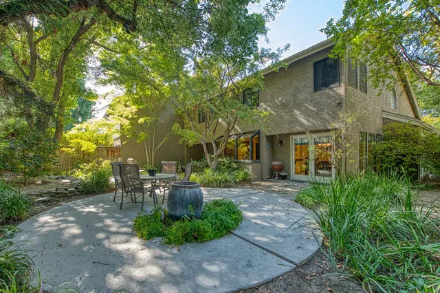 a view of a yard with table and chairs under an umbrella