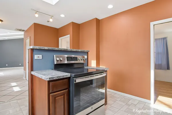 a kitchen with stainless steel appliances granite countertop a stove a sink and a microwave