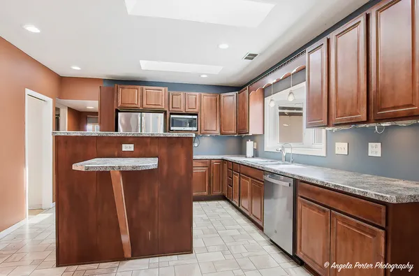 a kitchen with stainless steel appliances granite countertop wooden cabinets a sink and a stove