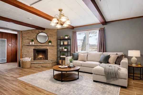 a living room with furniture a fireplace and a large window