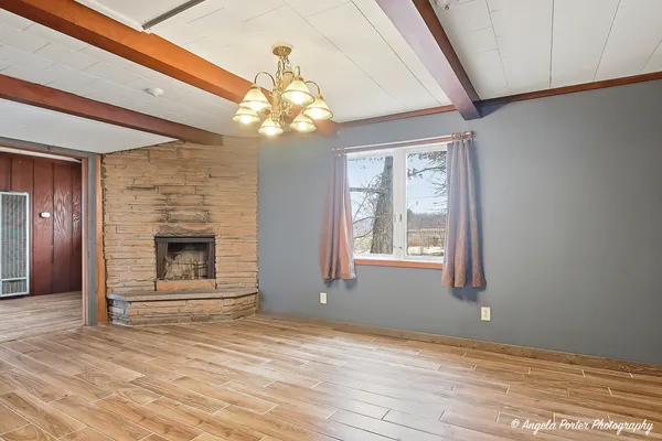 a view of a livingroom with a fireplace window and wooden floor