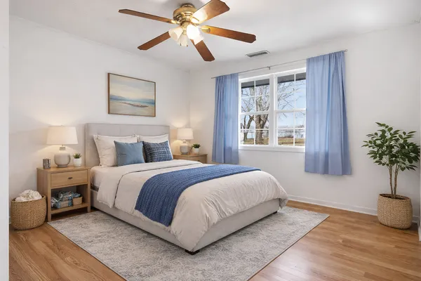 a bedroom with a large bed and a potted plant