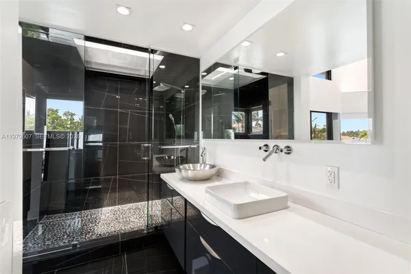 a bathroom with a sink a large mirror and a shower